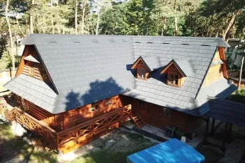 Plastový střešní šindel na roubence v modřínovém háji