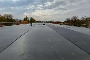 Plochá střecha bytového domu po pokládce EPDM fólie Prelasti Fleece, pásy svařené do souvislé plochy.